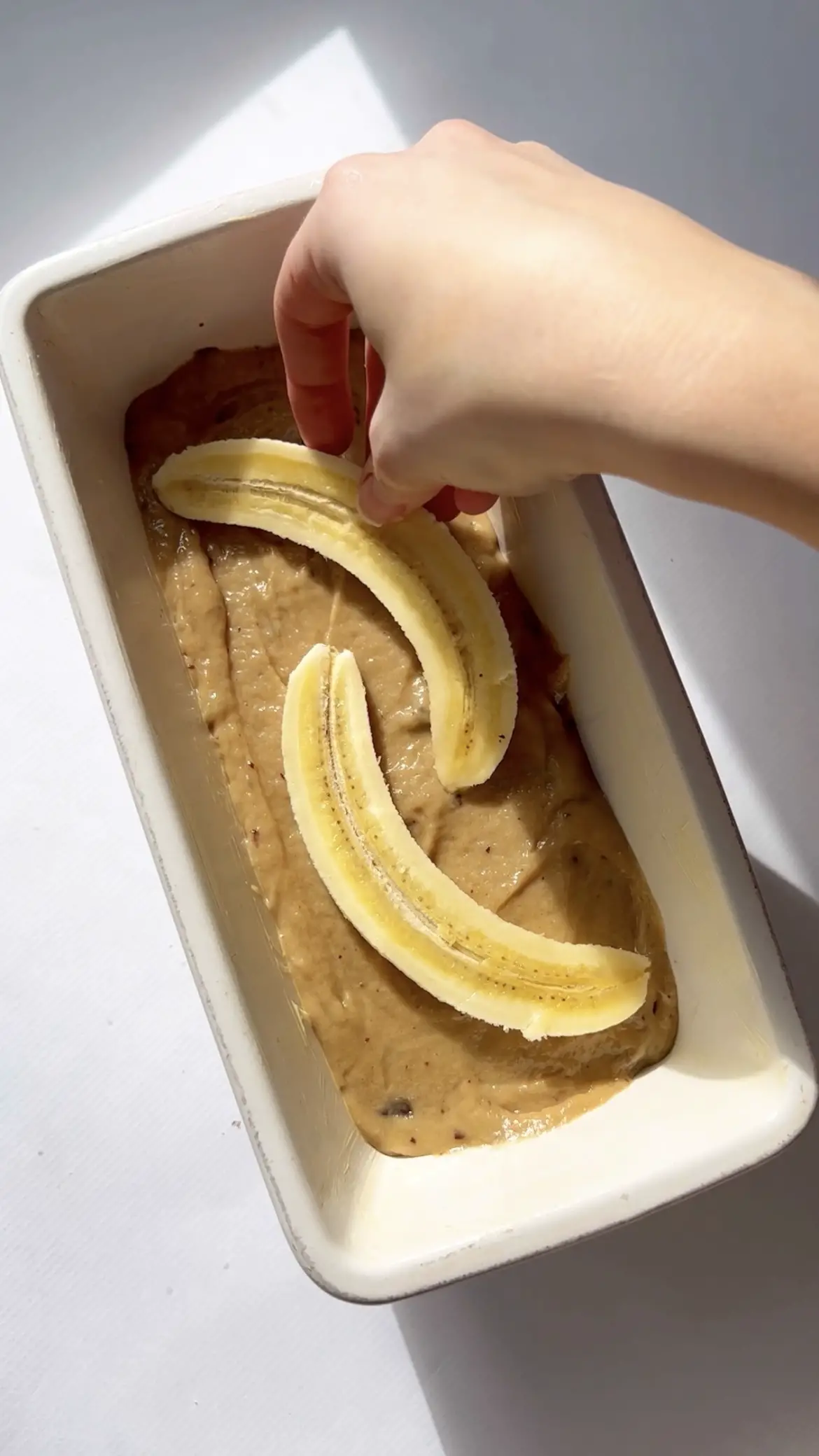adding banana to the banana bread