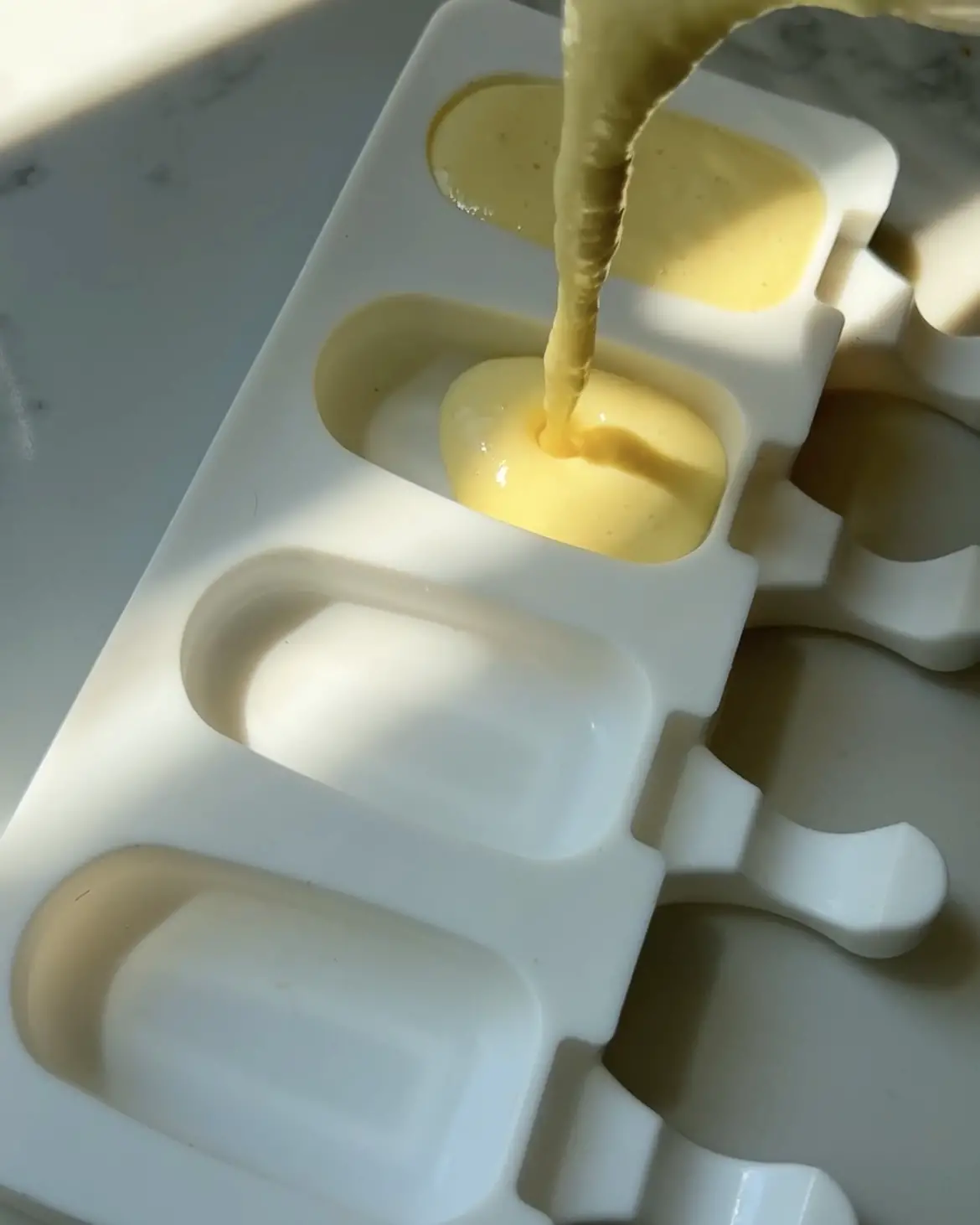 Pour the Mango White Chocolate Yoghurt pops into moulds